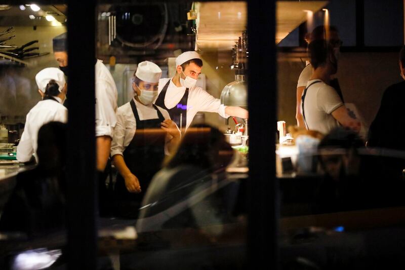 Waiters serve customers sitting inside a restaurant at Patriarshiye Prudy in Moscow, Russia. AP Photo
