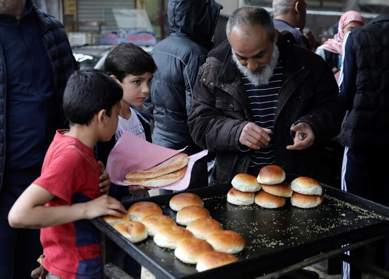 People buy traditional bread at a bakery before the time for iftar, or breaking fast, on the first day of the holy month of Ramadan, as the spread of the coronavirus disease (COVID-19) continues, in the rebel-held Idlib city, Syria April 24, 2020. REUTERS/Khalil Ashawi