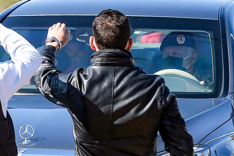 People stand on the side as Jordan's King Abdullah II arrives in his vehicle at a hospital in the town of Salt, northwest of the capital. AFP