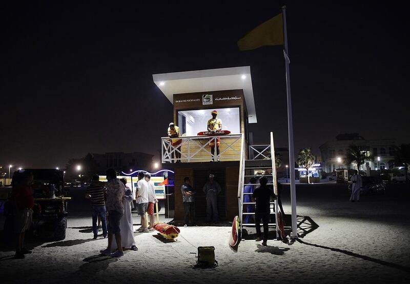 Lifeguards turn night watchmen as night swimming begins at Umm Suqeim Beach in Dubai on Sunday. Anna Nielsen for The National