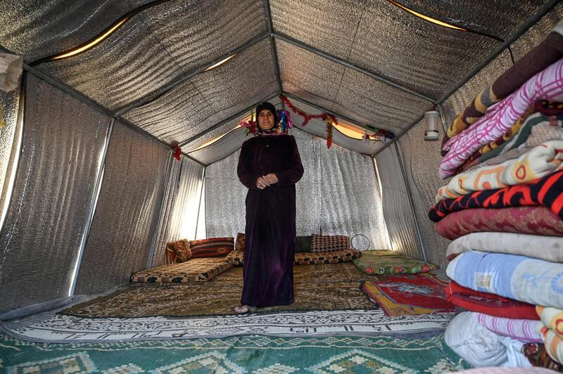 Noora Al Ali, who fled regime attacks on the town of Maaret Al Numan with her son and eight grandchildren, stands inside her new concrete come at the Kafr Lusin camp. AFP