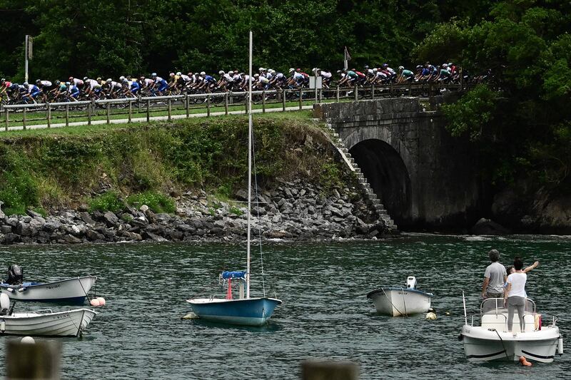 Spectators on a boat cheer the riders. AFP