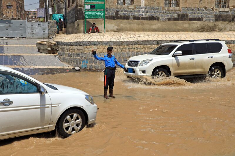 A police officer directs traffic along a flooded street in Sanaa. AFP