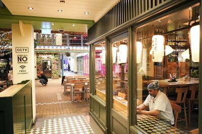 FILE PHOTO: A restaurant worker sits in the window of an empty restuarant, as the number of coronavirus (COVID-19) cases grow around the world, in London, Britain, March 17, 2020. REUTERS/Henry Nicholls/File Photo