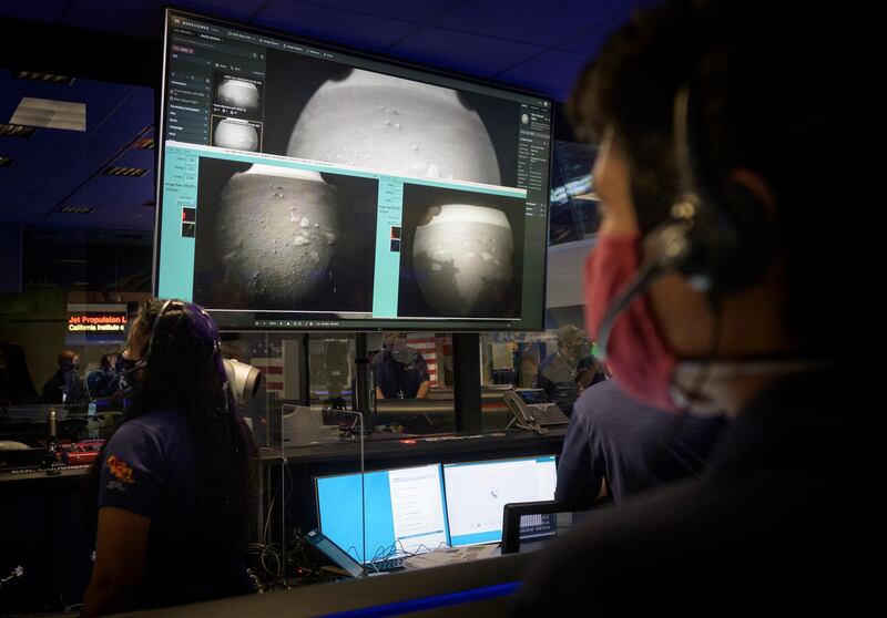 Members of Nasa's Perseverance Mars rover team watch in mission control as the first images arrive moments after the spacecraft successfully touched down on Mars. Nasa via AP