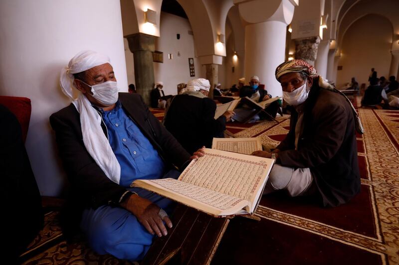 People wearing protective face masks read verses from the holy Quran at a mosque during Ramadan in Sana'a, Yemen. EPA