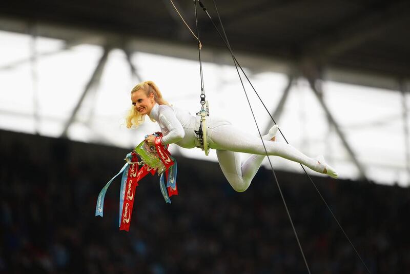 An acrobat delivers the cup prior to the League Cup final on March 2, 2014. Michael Regan / Getty Images