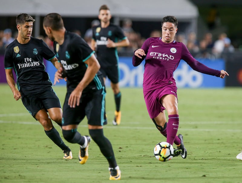 (FILES) This file photo taken on July 26, 2017 shows Manchester City's Samir Nasri (R) driving the ball against Real Madrid during the International Champions Cup football match in Los Angeles, California. 
Former French international midfielder Samir Nasri  signed on August 21, 2017 a two year deal to join Turkish top flight side Antalyaspor from Manchester City, the club said. / AFP PHOTO / RINGO CHIU