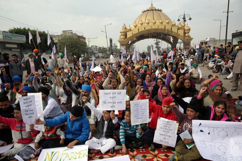 Farmers and their families block a national highway during a nation-wide strike call given by various farmers' organisations as a protest against the new agricultural laws introduced by the government and to demand a roll-back of those laws, in Amritsar, India. EPA