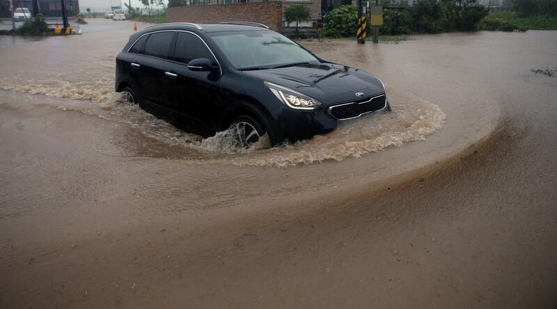 An SUV vehicle drives through a submerged road caused by typhoon Haishen in Gangneung, South Korea. Reuters