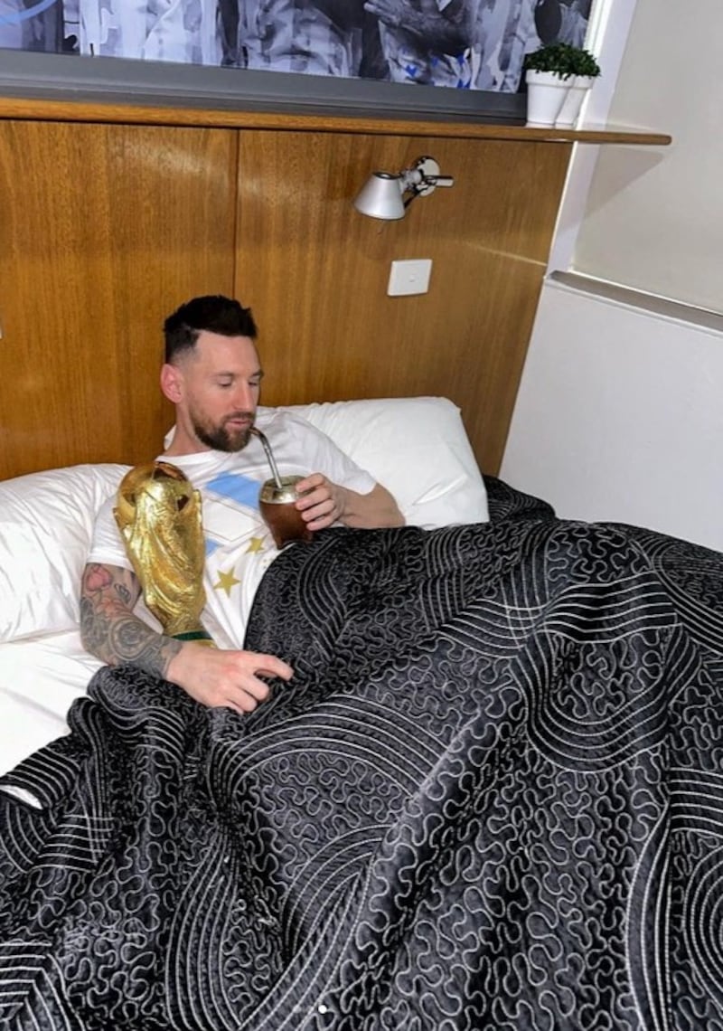 Argentina's Lionel Messi lies in bed with the World Cup trophy. Reuters