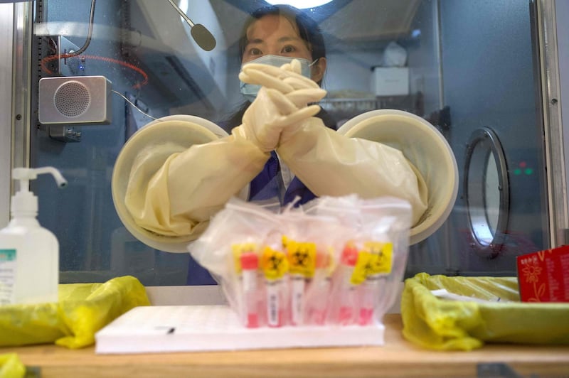 A medical worker waits for the next individual to take a swab test for the COVID-19 coronavirus at a hospital in Beijing. AFP