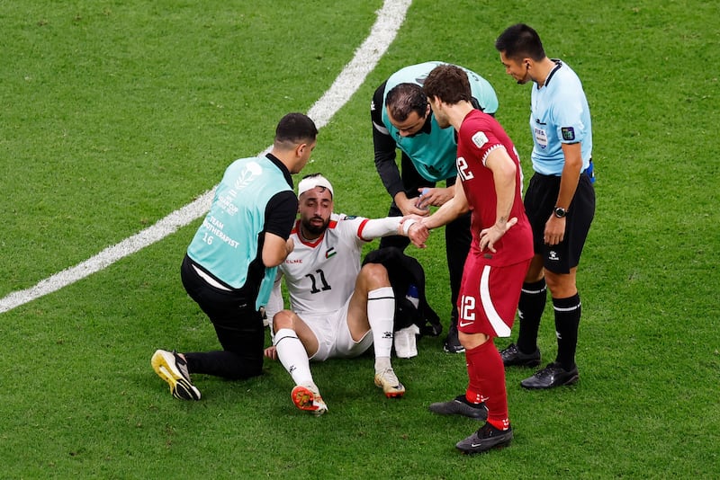 Palestine's Oday Dabbagh receives medical attention after sustaining an injury. Reuters