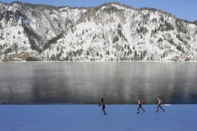 Enthusiasts of winter swimming warm up on the bank of the Yenisei River on January 27, 2017 in -26C temperatures, ahead of their weekly dip in the Siberian town of Divnogorsk, Russia. Ilya Naymushin
