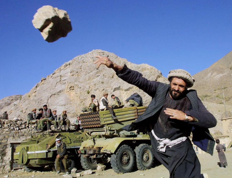 395753 02: A Northern Alliance fighter throwing rocks as part of a popular national game yards away from a multiple Grad missile launcher October 12, 2001 in the Salang Gorge in Northern Afghanistan. (Photo by Oleg Nikishin/Getty Images)