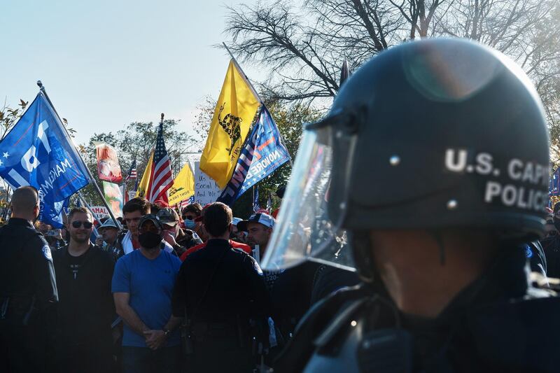 A US Capitol police officer looks on as Trump supporters, seen in the background, gather in front of the Supreme Court, in Washington, DC.  EPA
