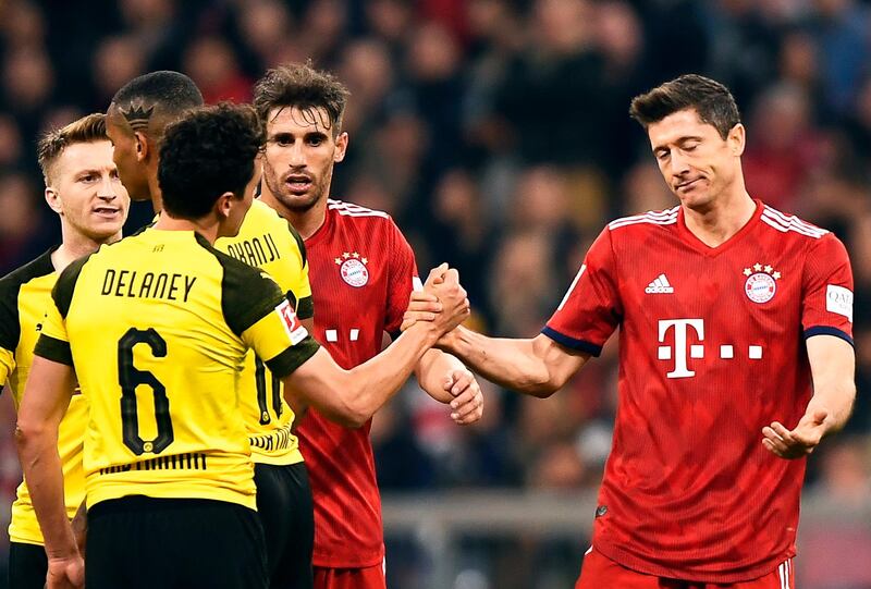 epa08323734 (FILE) - A file picture of Bayern's Robert Lewandowski (R) and Dortmund's Thomas Delaney (L) shaking hands during the German Bundesliga soccer match between FC Bayern Munich and Borussia Dortmund in Munich, Germany, 06 April 2019.  As media reports players of Bayern Munich and Borussia Dortmund agreed on a 20 % pay cut for the time the Bundesliga is interrupted due to the Coronavirus pandemic.  EPA/LUKAS BARTH-TUTTAS *** Local Caption *** 55108354