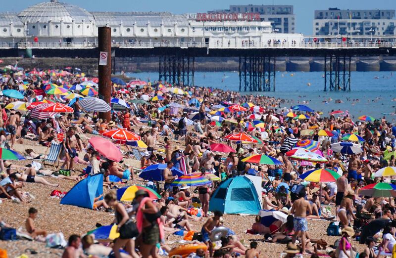 People gather on the beach during hot weather in Brighton.