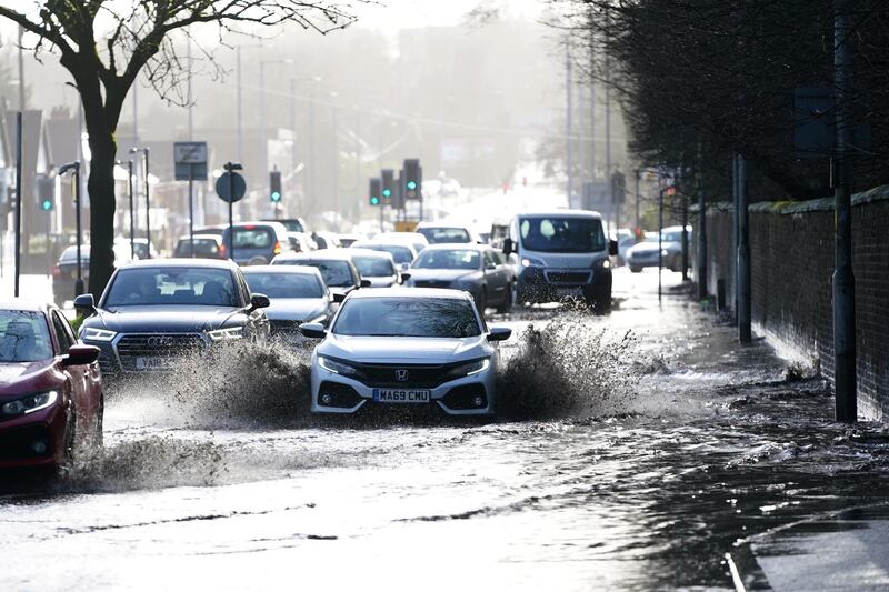 Cars drive through floodwater as hurricane-force winds and rain affected the country's transport network leading to disruptions and prompting warnings of power cuts and a risk to life, in Manchester, Britain. REUTERS