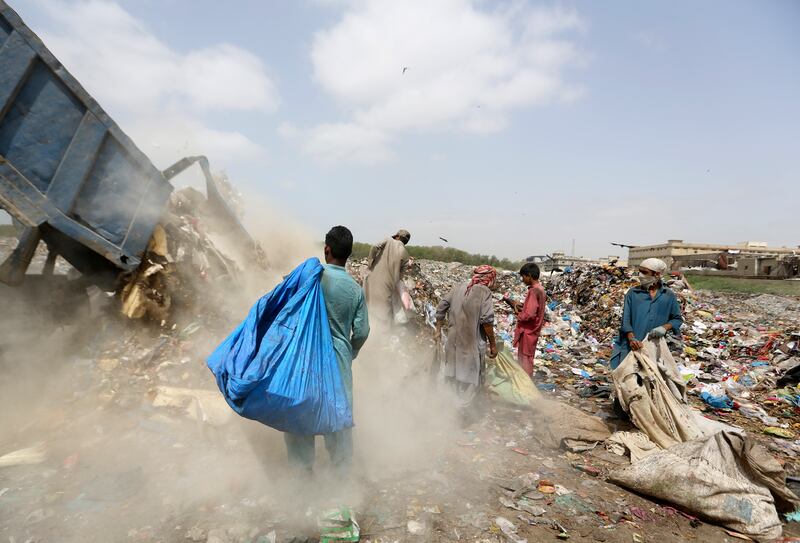 Afghan refugees search for recyclable material from heaps of rubbish in Karachi, Pakistan. AP