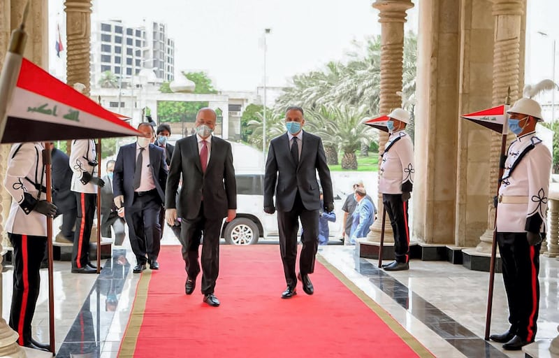 This handout photograph released by the Iraqi President's Office on May 28, 2020 shows President Barham Salih (C-L) receiving Prime Minister Mustafa Kadhimi (C-R) at Salam Palace in the capital Baghdad, while both clad in masks due to the COVID-19 coronavirus pandemic. (Photo by - / Iraqi Presidency Media Office / AFP) / === RESTRICTED TO EDITORIAL USE - MANDATORY CREDIT "AFP PHOTO / HO / IRAQI PRESIDENT'S PRESS OFFICE" - NO MARKETING NO ADVERTISING CAMPAIGNS - DISTRIBUTED AS A SERVICE TO CLIENTS ===