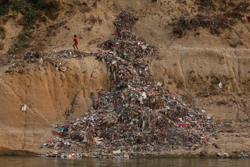 A boy runs past a pile of garbage along the river Ganges in Mirzapur, India, April 19, 2017. REUTERS/Danish Siddiqui  SEARCH "SIDDIQUI GANGES" FOR THIS STORY. SEARCH "WIDER IMAGE" FOR ALL STORIES.