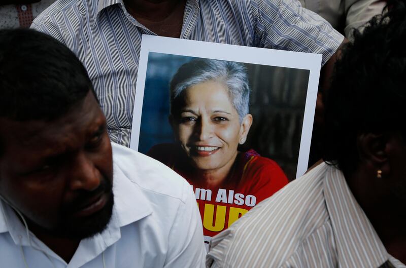 A participant holds a placard with a photograph of Indian journalist Gauri Lankesh at a protest demonstration against her killing in Bangalore, India, Wednesday, Sept. 6, 2017. The Indian journalist was gunned down outside her home the southern city of Bangalore �������� the latest in a string of deadly attacks targeting journalists or outspoken critics of religious superstition and extreme Hindu politics. (AP Photo/Aijaz Rahi)