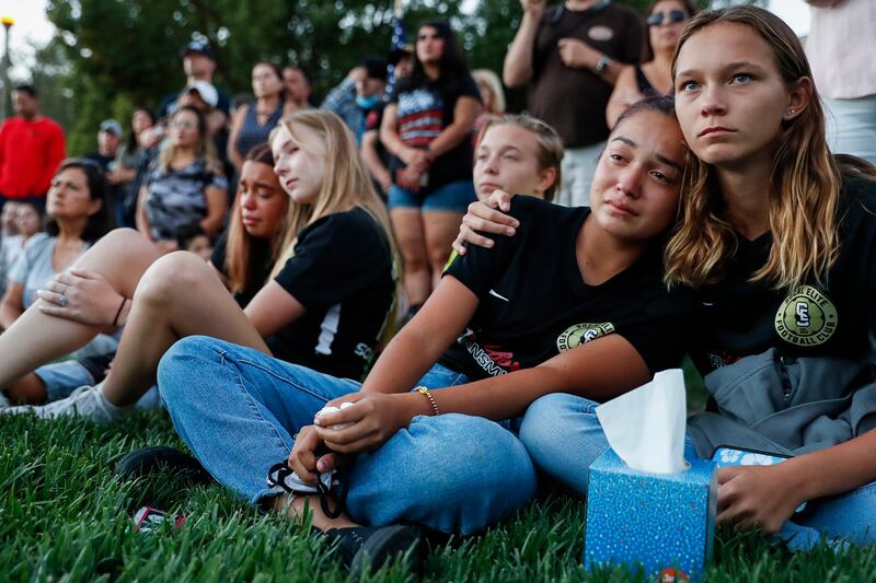 Gabby Ramirez, left, and Breanna Sanvnark watch a ceremony to honour the late LCpl  Dylan Merola at Central Park in Rancho Cucamonga, California. EPA
