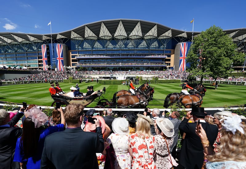 Race-goers watch the royal procession go by the parade ring ahead of day one of Royal Ascot. PA