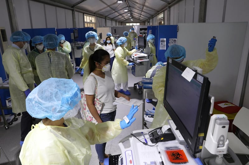 A woman waits to be tested by medical staff wearing protective equipment, amid the coronavirus disease (COVID-19) outbreak, at the Cleveland Clinic hospital in Abu Dhabi, United Arab Emirates, April 20, 2020. Picture taken April 20, 2020. REUTERS/Christopher Pike
