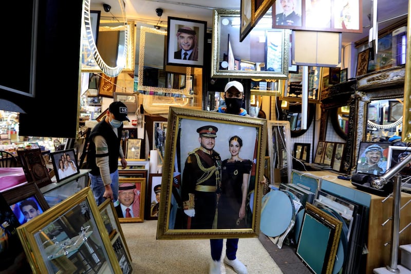 A frame maker in Amman displays pictures of king Abdullah II. EPA
