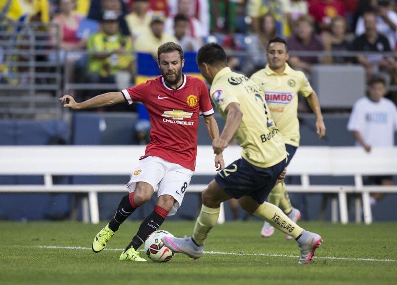 Juan Mata of Manchester United tries to dribble around Club America's Paolo Goltzin during their friendly match on Friday. Stephen Brashear / AFP