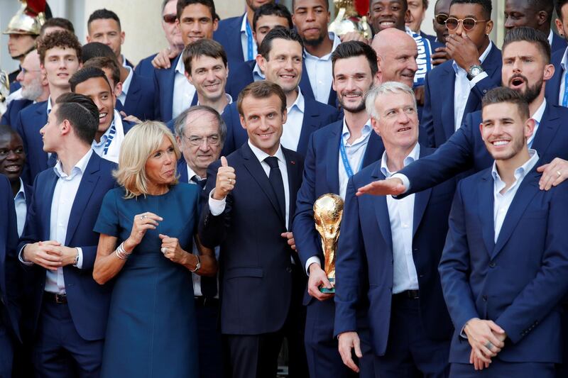 French President Emmanuel Macron and his wife Brigitte Macron pose with France soccer team captain Hugo Lloris holding the trophy, coach Didier Deschamps and players before a reception to honour the France soccer team after their victory in the 2018 Russia Soccer World Cup, at the Elysee Palace in Paris, France, July 16, 2018. REUTERS/Philippe Wojazer