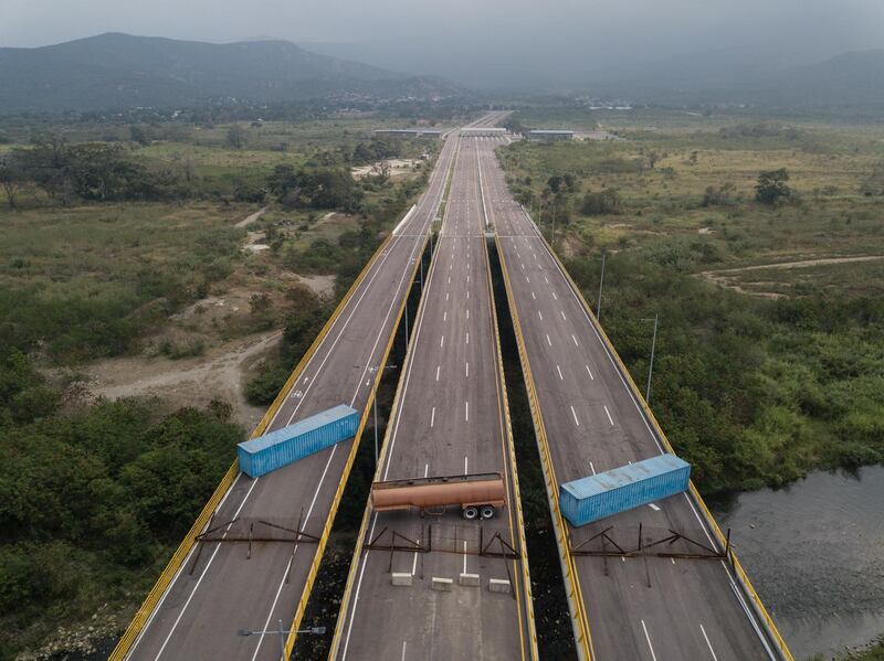 A gas tank and shipping containers obstructing passage to Venezeula are seen on the Tienditas International Bridge in an aerial photograph taken over Cucuta, Colombia, on Wednesday, Feb. 6, 2019. Venezuela's Nicolas Maduro has an offer for the U.S.: If you want to bring humanitarian aid into the country, you must lift economic sanctions first. Photographer: Ivan Valencia/Bloomberg