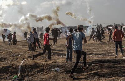 epa06741577 Palestinians protesters run for cover from Israeli tear-gas during clashes after near the border with Israel in the east of Gaza Strip, 15 May 2018 (issued 16 May 2018). According to Palestinian medical sources, two Palestinian protesters were shot dead by the Israeli army on 15 May in Gaza, while thousands of Palestinians attended the funerals for some 25 of the 60 protesters killed a day earlier by the Israeli army during mass demonstrations. Palestinians are marking the Nakba Day, or the day of the disaster, when more than 700 thousand Palestinians were forcefully expelled from their villages during the war that led to the creation of the state of Israel on 15 May 1948. Protesters call for the right of Palestinians to return to their homeland.  EPA/MOHAMMED SABER