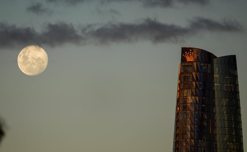 The Moon appears larger than usual as it rises above the Barangaroo tower in Sydney. AP