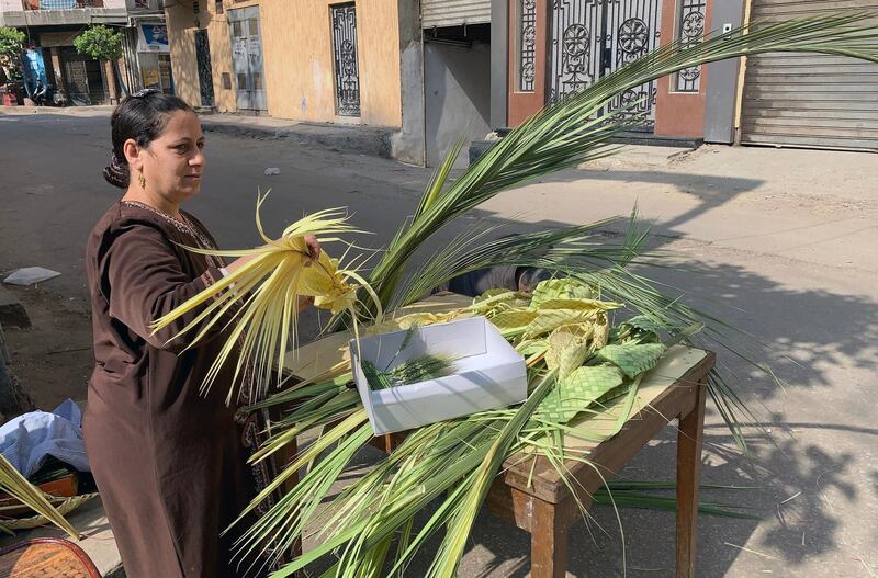 A woman prepares palm leave products as Egyptian Coptic Christians celebrate Palm Sunday, at Ghamra district in Cairo, Egypt.  EPA