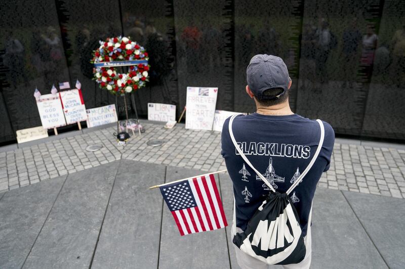 David Romley of Germantown, Md, holds an American flag as he visits the Vietnam Veterans Memorial after Cindy McCain placed a wreath. AP