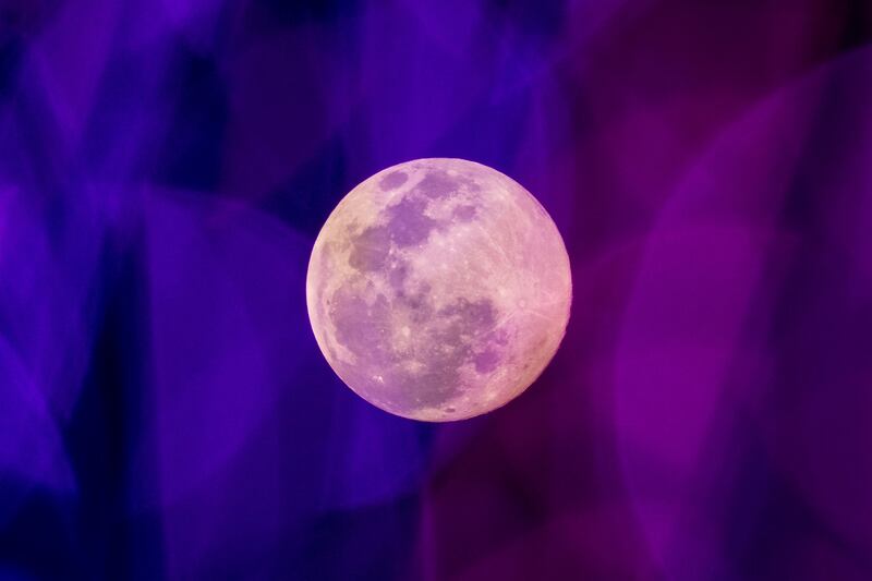 The Wolf Moon, the first full moon of the year, is pictured through coloured fairy lights hanging outside a shopping mall in Bangkok, Thailand. AFP