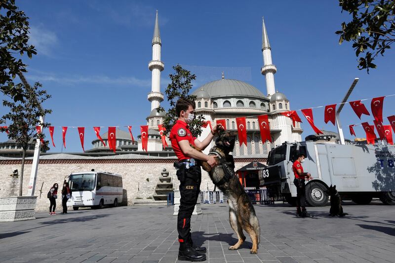 A member of Turkish Police Dog Training Centre plays with a K-9 dog at Taksim Square during a nationwide "full closure" in central Istanbul. Reuters