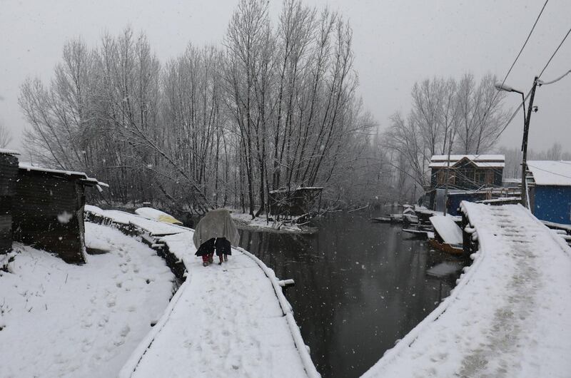 Kashmiri children walk on a snow covered wooden path on the interior of Dal Lake in Srinagar.  Farooq Khan / EPA
