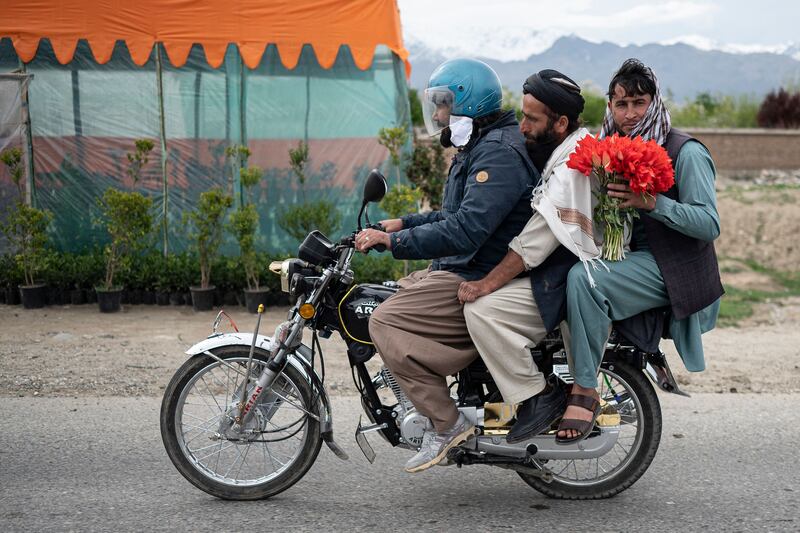 Afghan men ride a motorbike along a roadside in Mir Bacha Kot district of Kabul province. AFP