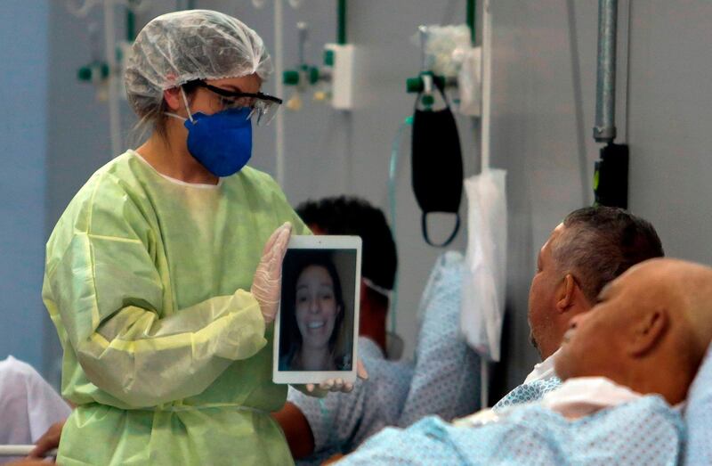 A patient affected by the Covid-19 speaks with a family member by a video call at a field hospital set up at a sports gym, in Santo Andre, Sao Paulo state, Brazil. AFP