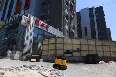 A Zhen Robotics delivery robot makes its way from a Suning supermarket to a residential compound during a demonstration of the robot in Beijing. Along a quiet residential street on the outer edges of Beijing, a yellow and black cube about the size of a small washing machine trundles leisurely to its destination. This "little yellow horse" is an autonomous delivery robot, ferrying daily essentials like drinks, fruit and snacks from the local store to the residents of the "Kafka" compound in the Chinese capital.
 - TO GO WITH AFP STORY CHINA-TECHNOLOGY-ROBOTS-CONSUMER-SCIENCE,FEATURE BY LUDOVIC EHRET
 / AFP / GREG BAKER / TO GO WITH AFP STORY CHINA-TECHNOLOGY-ROBOTS-CONSUMER-SCIENCE,FEATURE BY LUDOVIC EHRET
