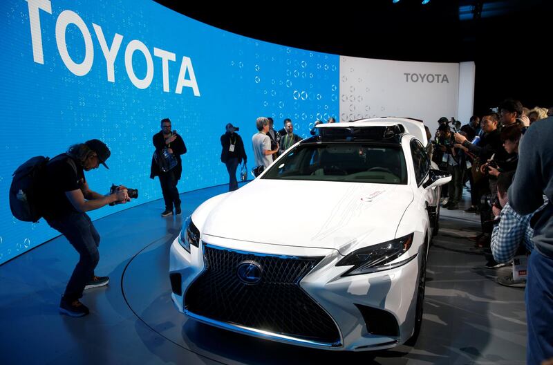 Photographers take photos of a research vehicle equipped with Toyota Guardian, an accident avoidance system that assists drivers. Reuters