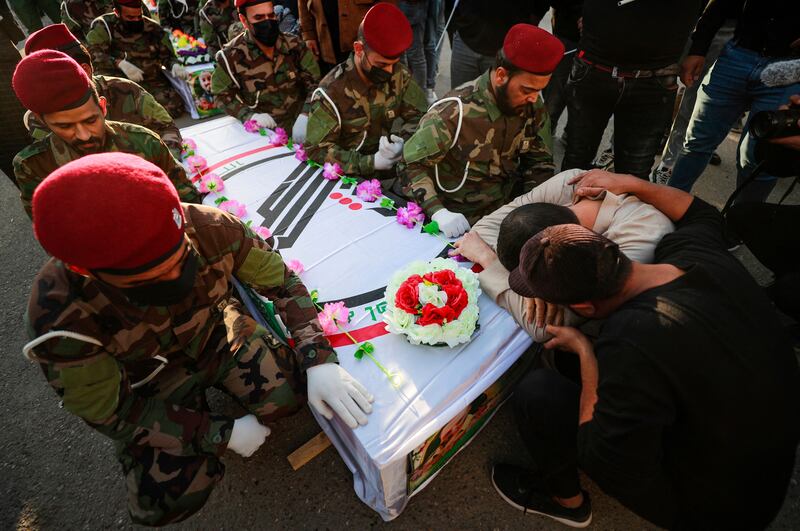 Iraqis cry next to the coffin of a fighter killed in a US strike during a funeral in Baghdad in November. AFP