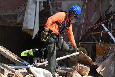 A Chilean rescue worker and a dog search for victims through the rubble of a building that collapsed in the August 4 explosion at the nearby Beirut seaport, in the Lebanese capital's neighbourhood of Gemayzeh, on September 2, 2020. Hundreds of tonnes of ammonium nitrate, a highly explosive fertiliser, exploded at Beirut's port on August 4 this year causing severe damage across swathes of the Lebanese capital as well as killing and injuring scores of people. / AFP / -