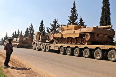 A boy looks at a convoy of Turkish military vehicles near the town of Hazano in Syria's Idlib province on March 3, 2020. AFP