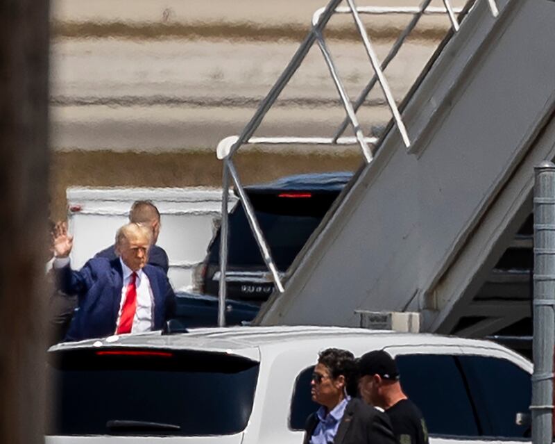 Mr Trump waves as he heads to the stairs to board his private plane in Florida. AP
