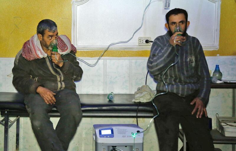 Syrian men wear oxygen masks at a make-shift hospital following a reported gas attack on the rebel-held besieged town of Douma in the eastern Ghouta region on the outskirts of the capital Damascus on January 22, 2018. 
At least 21 cases of suffocation, including children, were reported in Syria in a town in eastern Ghouta, a beleaguered rebel enclave east of Damascus, an NGO accusing the regime of carrying out a new chemical attack said. Since the beginning of the war in Syria in 2011, the government of Bashar al-Assad has been repeatedly accused by UN investigators of using chlorine gas or sarin gas in sometimes lethal chemical attacks.
 / AFP PHOTO / HASAN MOHAMED